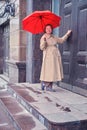 Adult happy woman knocking on the door of an old house