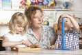 Adult Helping Two Young Children at Montessori/Pre Royalty Free Stock Photo