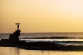 Adult holding on his arms up a bike at the beach on a big rock - freedom concept and lifestyle - great sunset - ocean and sea with Royalty Free Stock Photo