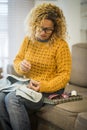 Adult housewife at home repairing clothes with cord - sailor and sew jeans jacket -beauiful young woman in activiy at home sitting Royalty Free Stock Photo
