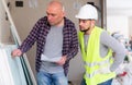 Adult interior designer giving instructions to construction team foreman Royalty Free Stock Photo