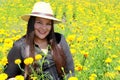 Adult latin woman with hat walks in field of red flowers, flower for day of the dead in Mexico Royalty Free Stock Photo