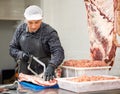 Adult male butcher sawing beef ribs