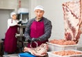 Adult male butcher sawing beef ribs