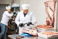 Adult male butcher sawing beef ribs