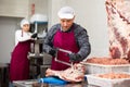 Adult male butcher sawing beef ribs