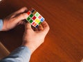 Adult male Caucasian hands hold Rubik\'s cube