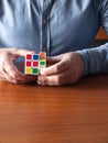 Adult male Caucasian hands hold Rubik\'s cube