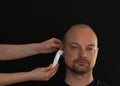 Adult male having his temperature taking with a digital ear thermometer Royalty Free Stock Photo