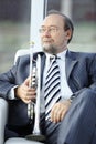 Adult male musician sitting in a chair Royalty Free Stock Photo