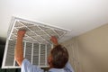 Adult Male Removing Air Filter from a Home Furnace Ceiling Vent Royalty Free Stock Photo