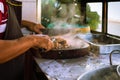 Adult male taquero cutting meat at a Mexican restaurant to prepare carnitas tacos. Royalty Free Stock Photo