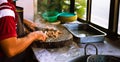 Adult male taquero cutting meat at a Mexican restaurant to prepare carnitas tacos. Royalty Free Stock Photo