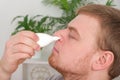 An adult male uses a nasal spray to relieve a runny nose. concept of medicine, health. Royalty Free Stock Photo