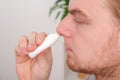 An adult male uses a nasal spray to relieve a runny nose. concept of medicine, health. Royalty Free Stock Photo