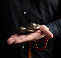 Adult man in black clothes holds in his hands a pair of bronze Karatal on a leather rope Royalty Free Stock Photo