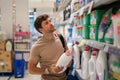 Male customer choosing detergent from shelf