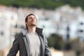 Adult man breaths deeply fresh air in a rural town in winter