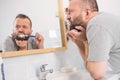 Bored guy brushing his teeth in bathroom Royalty Free Stock Photo