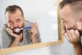 Bored guy brushing his teeth in bathroom Royalty Free Stock Photo