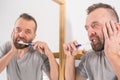 Bored guy brushing his teeth in bathroom