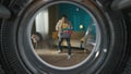 View from inside the empty washing machine young man in the room with laundry basket Royalty Free Stock Photo