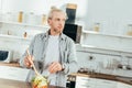 adult man cooking vegetable salad and looking away Royalty Free Stock Photo