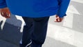 An adult man crossing a pedestrian crossing. He`s limping on one leg because he has cerebral palsy