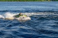 An adult man cuts the waves on a jet ski in the blue water of the Dnieper River in Kherson Ukraine. Active recreation on the Royalty Free Stock Photo