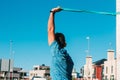 Adult man doing triceps and shoulder stretches in city park. Working trx outdoors, health and fitness concept Royalty Free Stock Photo