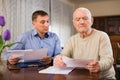 Adult man with elderly father analyzing papers Royalty Free Stock Photo