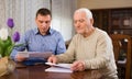 Adult man with elderly father analyzing papers Royalty Free Stock Photo