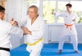 Adult and elderly men training karate fight