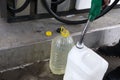 Adult man fills a car with petrol at a fuel station in the winter. refueling nozzle man holding in his hand, pouring the liquid in Royalty Free Stock Photo