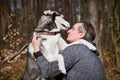 Adult man in gray sweatshirt hugs beloved Siberian Husky dog, true love of human and pet