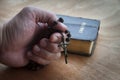 Adult man hand holding Holy Rosary while praying with Bible background. Religious concept Royalty Free Stock Photo