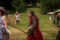 Adult man in medieval warrior clothes among people in modern clothes