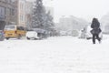 Adult man passing the winter city road in the heavy snowy storm.