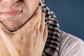 Man with cold and flu illness suffering from sore throat. Blue background Royalty Free Stock Photo