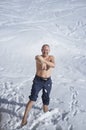 Adult man practicing cryotherapy, in the snow