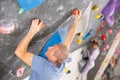 Adult man practicing rock climbing on climbing wall Royalty Free Stock Photo