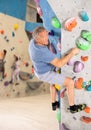 Adult man practicing rock climbing on climbing wall Royalty Free Stock Photo