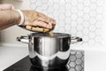 Adult man's hands pouring Italian pasta into a pot of boiling water