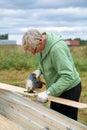 An adult man sawing boards electric jigsaw for building a house