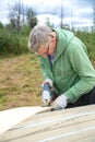 An adult man sawing boards electric jigsaw for building a house