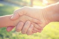 an adult man shakes hands with a child. The concept of salvation