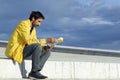 Adult man with sportswear sitting on a summer sunny day reading a book