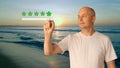 An adult man standing on the beach by the sea at sunset shows an excellent rating for the resort. A high score of 5 Royalty Free Stock Photo