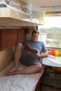 An adult man on a train with a book in his hand goes on vacation