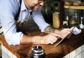 Adult Man Using Tablet in Bakery Shop Royalty Free Stock Photo